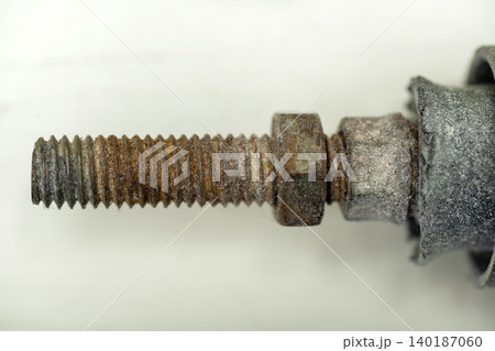 A detailed macro shot of a heavily rusted steel bolt with corroded hex nuts, showcasing metallic texture, decay, and oxidation on a neutral background A detailed macro shot of a heavily rusted steel bolt with corroded hex nuts, showcasing metallic texture, decay, and oxidation on a neutral background 140187060