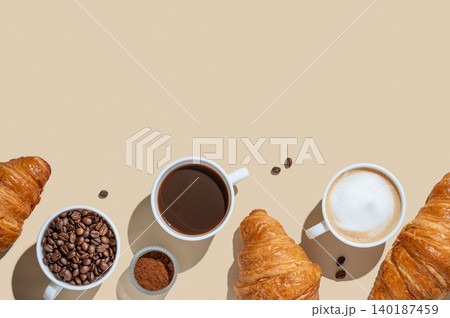 Cups of cappuccino, espresso, coffee beans and croissants on a yellow isolated background Cups of cappuccino, espresso, coffee beans and croissants on a yellow isolated background 140187459