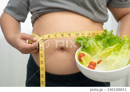 Asian woman with fat belly big size overweight and obesity with healthy food. 140188651