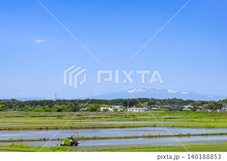 田植機による田植え作業と残雪の栗駒山 田植機による田植え作業と残雪の栗駒山 140188853