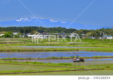 田植機による田植え作業と残雪の栗駒山 田植機による田植え作業と残雪の栗駒山 140188854