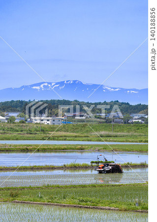 田植機による田植え作業と残雪の栗駒山 田植機による田植え作業と残雪の栗駒山 140188856
