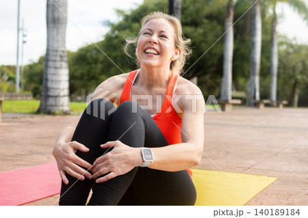 Cheerful Mid-Adult Woman Laughing After Outdoor Workout Cheerful Mid-Adult Woman Laughing After Outdoor Workout 140189184