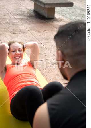 Mature Woman Doing Abs Workout on Yoga Mat Outdoors 140189225