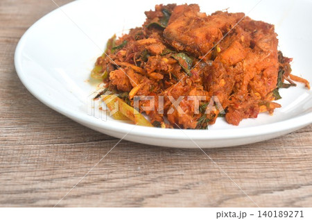 fried spicy slice stingray fish with finger root and basil leaf in curry sauce on plate fried spicy slice stingray fish with finger root and basil leaf in curry sauce on plate 140189271