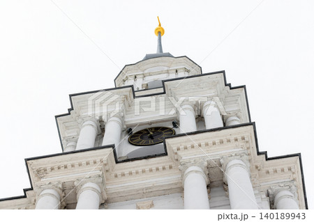 Close up photo of a tall white bell tower rises under overcast winter sky Close up photo of a tall white bell tower rises under overcast winter sky 140189943