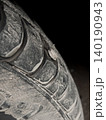 Closeup view of self tapping metal screw in car tire, dirt and grime on surface, need for repair. Deep rubber tread of damaged dusty vehicle wheel. Repair service, accident with punctured tires 140190943