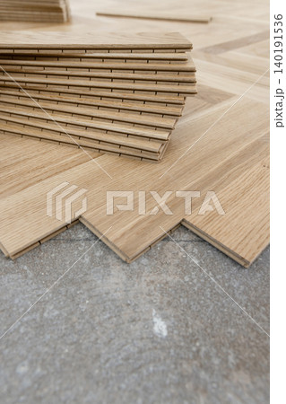 Beige parquet planks on floor during herringbone hardwood flooring installation. Apartment renovation Beige parquet planks on floor during herringbone hardwood flooring installation. Apartment renovation 140191536