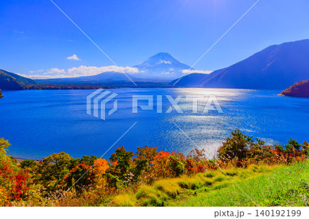 秋晴れの早朝 紅葉彩る本栖湖展望公園から望む冠雪の富士山と湖面のキラキラとした輝き 140192199