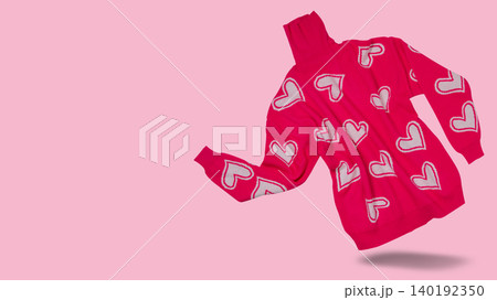 Bright pink knitted turtleneck sweater with white hearts pattern levitating on pastel pink background, copy space. Bright pink knitted turtleneck sweater with white hearts pattern levitating on pastel pink background, copy space. 140192350