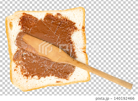 A slice of white toast bread with sweet chocolate hazelnut spread being applied with a wooden spatula. Top view of a delicious snack isolated. Perfect for food concepts. A slice of white toast bread with sweet chocolate hazelnut spread being applied with a wooden spatula. Top view of a delicious snack isolated. Perfect for food concepts. 140192466