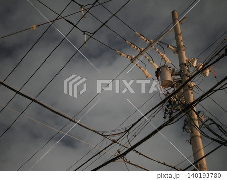 夜の街に立つ電柱と電線のシルエット 夜の街に立つ電柱と電線のシルエット 140193780