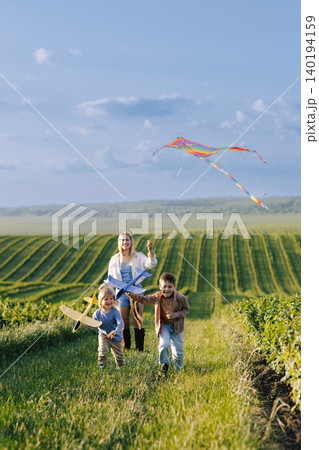 Family enjoying summer day flying kite and toy airplane Family enjoying summer day flying kite and toy airplane 140194159