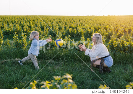 Mother and child playing ball in nature Mother and child playing ball in nature 140194243