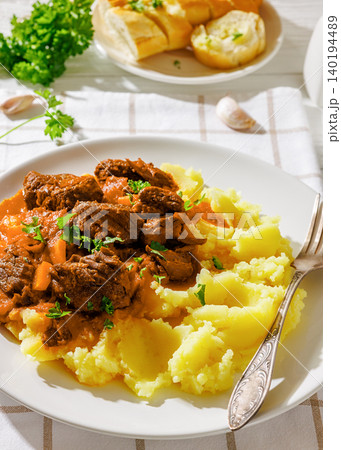 slow cooked beef meat stew served with mashed potatoes 140194489