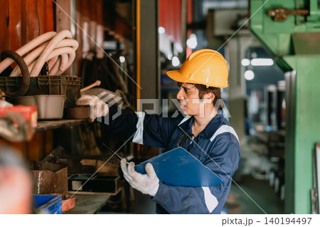 Staff worker man working in old metal part stock warehouse storage looking search for machine part. Staff worker man working in old metal part stock warehouse storage looking search for machine part. 140194497