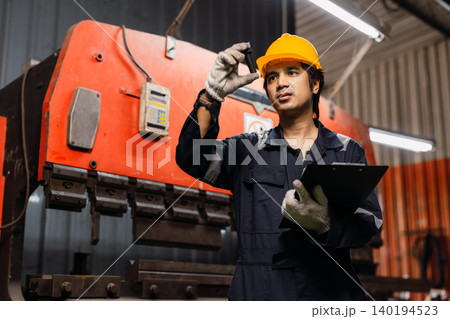 Professional Asian engineer male technician worker control operate machine in metal plant workshop. Professional Asian engineer male technician worker control operate machine in metal plant workshop. 140194523