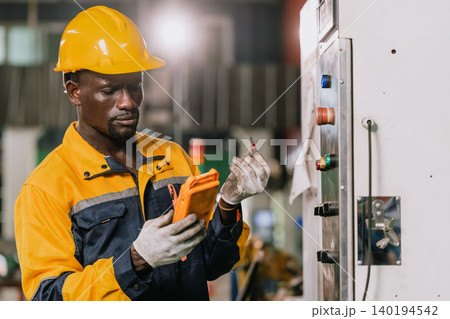 Professional African black engineer male technician expert worker control operate machine in plant Professional African black engineer male technician expert worker control operate machine in plant 140194542