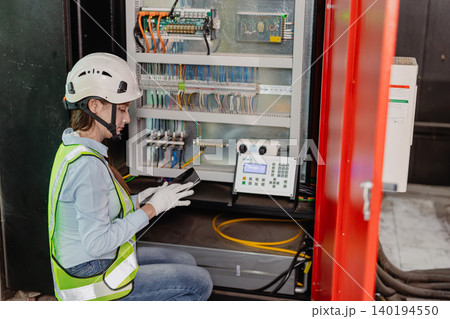 Industry Electrician, Engineer electricity technician woman check electric wire at industry machine. 140194550