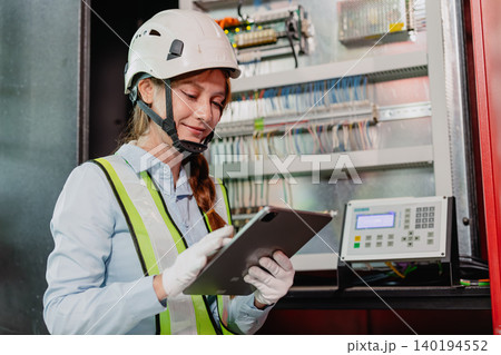 Industry Electrician, Engineer electricity technician woman check electric wire at industry machine. Industry Electrician, Engineer electricity technician woman check electric wire at industry machine. 140194552