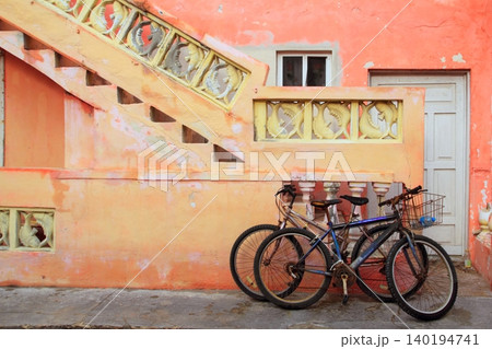bicycles on grunge tropical Caribbean orange facade 140194741