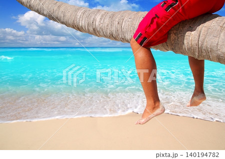 Caribbean inclined palm tree beach tourist legs Caribbean inclined palm tree beach tourist legs 140194782