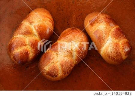 Three brioche pastries over orange clay Three brioche pastries over orange clay 140194928