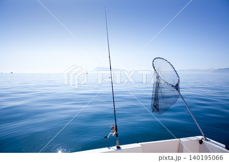 boat fishing rod and landing net in sea 140195066