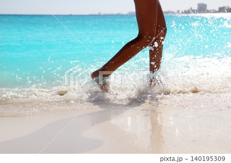 Woman legs walking splashing beach aqua water Woman legs walking splashing beach aqua water 140195309