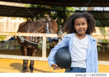 Horse riding child, Horseback rider training. African black children happy fun in stable horse farm Horse riding child, Horseback rider training. African black children happy fun in stable horse farm 140195699