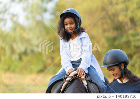 Horse riding child, Horseback rider training. African black children happy fun in stable horse farm Horse riding child, Horseback rider training. African black children happy fun in stable horse farm 140195710