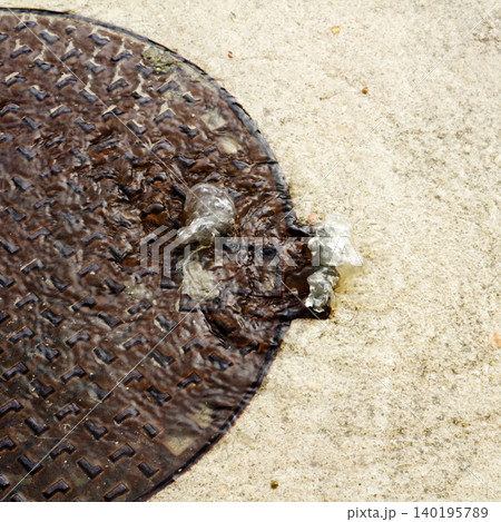 manhole overflowing water in a rainy day 140195789