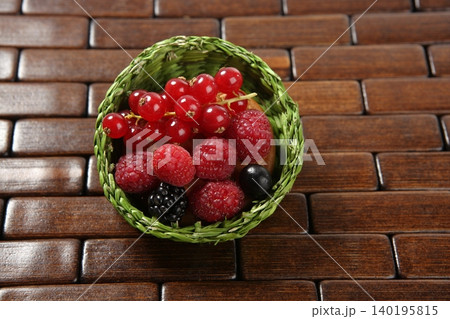 Mixed berries in a green little basket 140195815