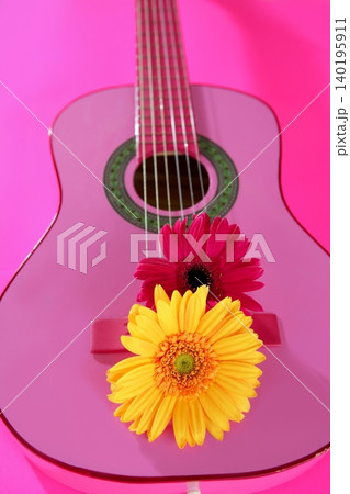 Hippie flower yellow pink gerbera on guitar Hippie flower yellow pink gerbera on guitar 140195911