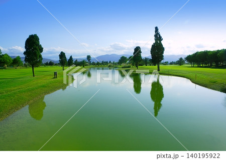 Golf course green grass field lake reflection Golf course green grass field lake reflection 140195922