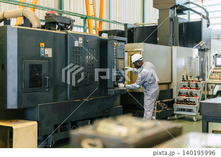 Professional African black worker, Engineer male working control CNC machine in industry factory Professional African black worker, Engineer male working control CNC machine in industry factory 140195996