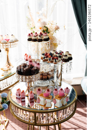Delicious desserts decorating elegant candy bar table for wedding reception 140196072