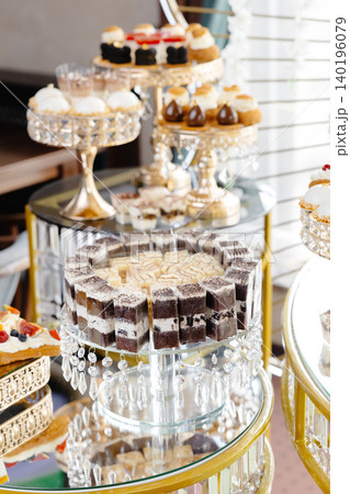 Delicious macarons and pastries decorating a luxurious candy bar buffet Delicious macarons and pastries decorating a luxurious candy bar buffet 140196079
