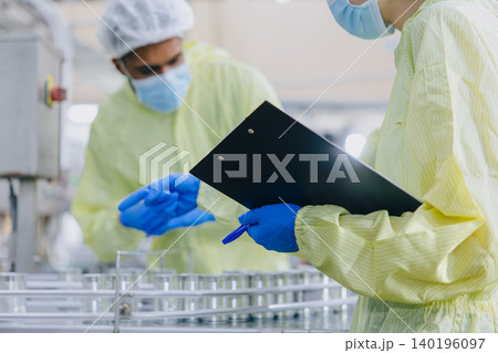 Food hygiene inspector team work examination food production process in line at cannery food factory Food hygiene inspector team work examination food production process in line at cannery food factory 140196097