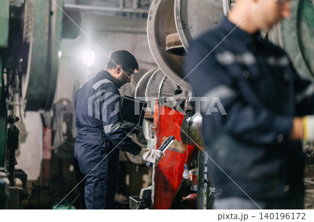 Mechanic Worker Hispanic Latin Indian male work service maintenance old Machine in metal plant 140196172