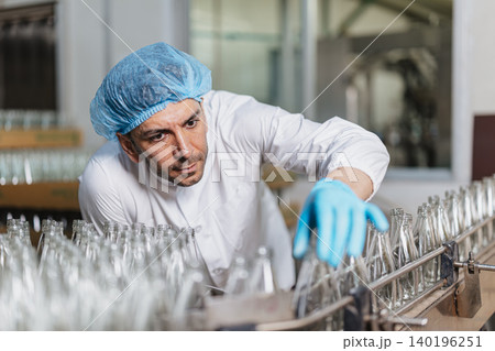 Glass bottle and food packaging manufacturing plant worker Product Visual Inspection in plant line. Glass bottle and food packaging manufacturing plant worker Product Visual Inspection in plant line. 140196251