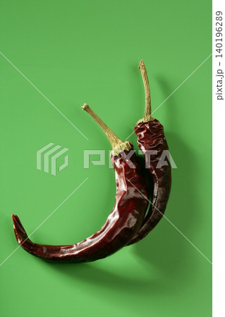 Two dried pepper, chili , over green background 140196289