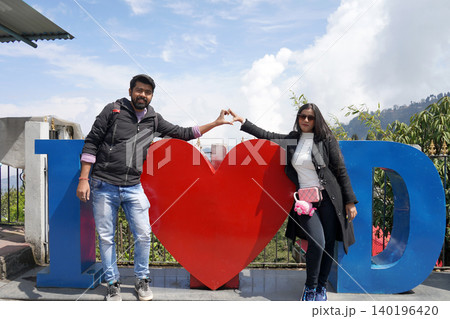 Happy couple making a heart shape with their hands at Batasia Loop in Darjeeling Happy couple making a heart shape with their hands at Batasia Loop in Darjeeling 140196420