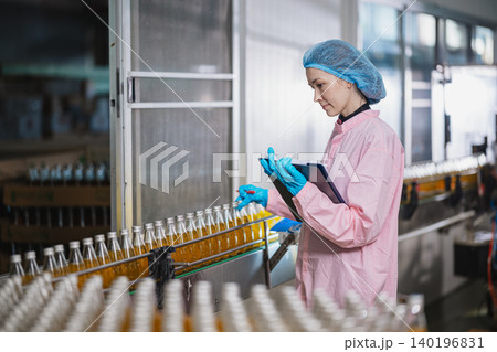 Food and drinks Industry staff working. Line product inspector in beverage factory for food safety. Food and drinks Industry staff working. Line product inspector in beverage factory for food safety. 140196831