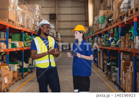 African black worker talking with young worker checking products warehouse stock for shipping order. African black worker talking with young worker checking products warehouse stock for shipping order. 140196923