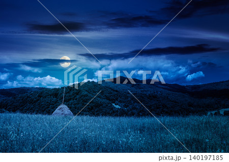 rural fields near pikui mountain in summertime at night. full moon over beautiful view of agricultural area. gorgeous mountain ridge with haystack on a grassy pasture. mysterious summer scenery rural fields near pikui mountain in summertime at night. full moon over beautiful view of agricultural area. gorgeous mountain ridge with haystack on a grassy pasture. mysterious summer scenery 140197185