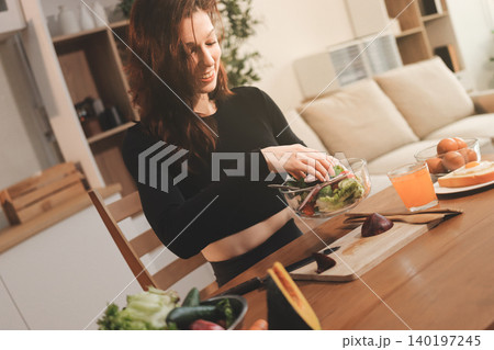 Woman preparing green smoothie in bright kitchen with fresh fruits and vegetables, healthy eating lifestyle moment in natural daylight Woman preparing green smoothie in bright kitchen with fresh fruits and vegetables, healthy eating lifestyle moment in natural daylight 140197245