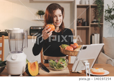 Woman preparing green smoothie in bright kitchen with fresh fruits and vegetables, healthy eating lifestyle moment in natural daylight Woman preparing green smoothie in bright kitchen with fresh fruits and vegetables, healthy eating lifestyle moment in natural daylight 140197254