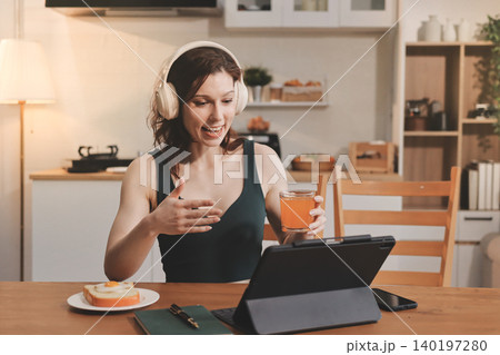 Woman preparing green smoothie in bright kitchen with fresh fruits and vegetables, healthy eating lifestyle moment in natural daylight 140197280
