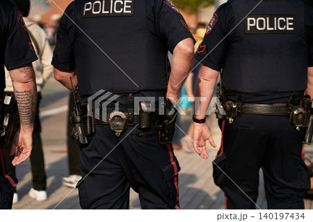 police officers in black uniforms walk down the street during the Stampede Parade in Calgary. police officers in black uniforms walk down the street during the Stampede Parade in Calgary. 140197434